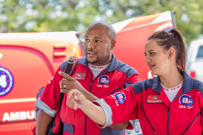 Male and female paramedic outside ambulance