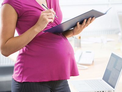 Schwangere steht bei der Arbeit