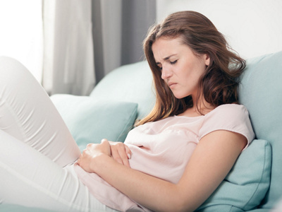Frau hält sich vor Schmerzen den Bauch