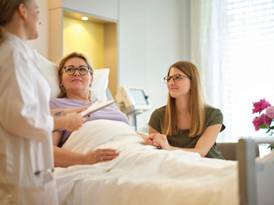 Ärztin mit Patientin und Angehöriger in einer der Hirslanden-Klinken