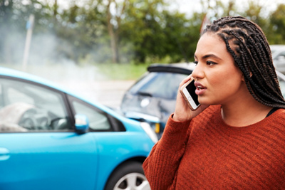 Person on phone at car accident scene