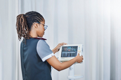 Nurse checking vital sign monitor