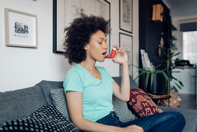 A woman using an inhaler 