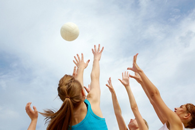 Action shot of a netball player catching a ball on an outdoor sports court 
