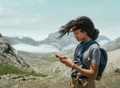 Hiker on her smartphone in the mountains