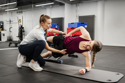 Physiotherapeutin unterstützt Patientin bei Übung