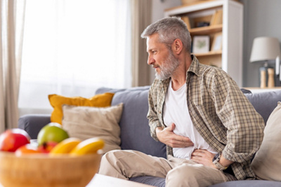 Mann mit Bauchschmerzen auf dem Sofa