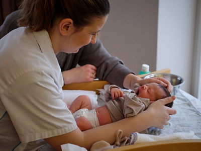 Pflegefachperson und Mutter kümmern sich um ihr Baby