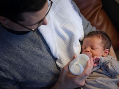 Vater füttert Baby mit Flasche