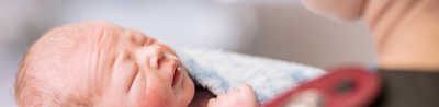 Baby being held by midwife