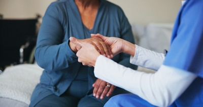 medical professional holding a patients hand