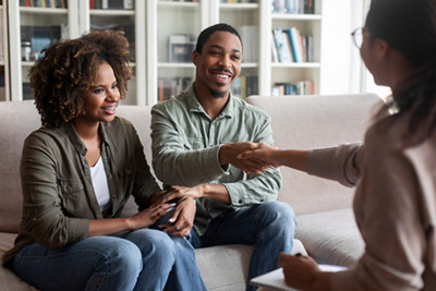 happy-african-couple-shaking-family-counselor-hand-successful-marital-therapy_resized