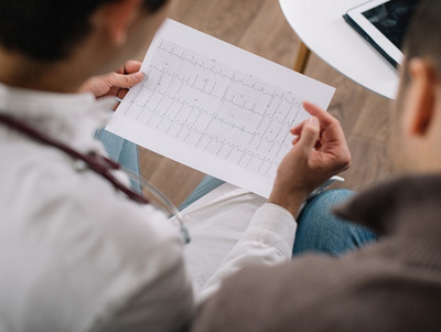 Arzt zeigt Herzrhythmusstörungen auf einer Auswertung