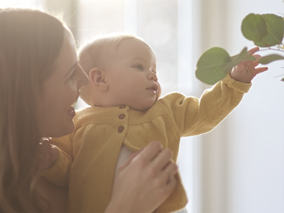 Aptaclub Mutter und Kind greifen nach Pflanze