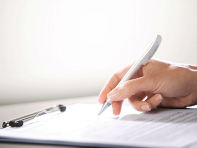 Nahaufnahme Hand mit Schreiber und Blatt