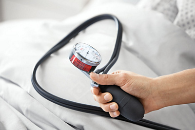 Hirslanden Herz, Fokus auf Blutdruck-Messung beim Patienten im Bett. 