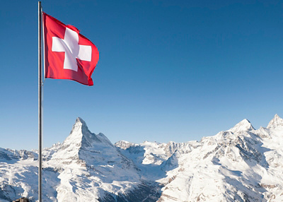 Aussicht auf Schweizer Berge mit Schweizer Fahne im Vordergrund