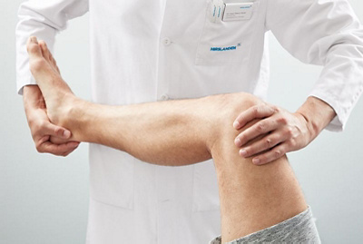 Arzt hält Knie eines Patienten