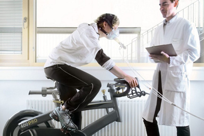 Patientin auf dem Velo bei einer Spiroergometrie. 