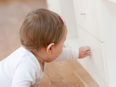 Baby greift an Schublade