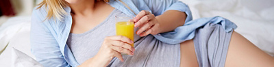 Schwangere trinkt ein Glas Fruchtsaft