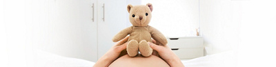Teddy auf Bauch von einer schwangeren Frau