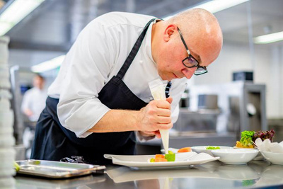 Dirk Matschke in der Küche am garnieren