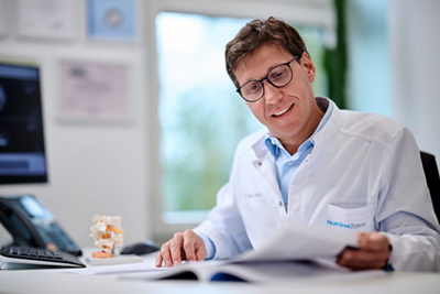 NeuroSpine Zürich - Prof. Dr. med. Sebastian Weckbach kontrolliert Unterlagen