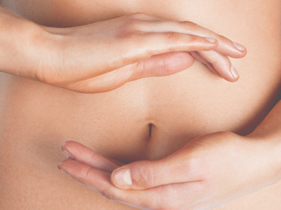 Frau hält sich die Hände schützend vor dem Bauch