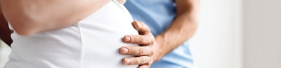 Man holds his hand on the belly of a pregnant woman
