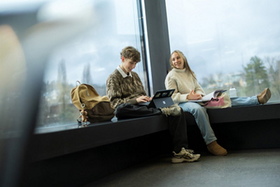 Zwei Jugendliche besprechen gemeinsam etwas in der Schule.