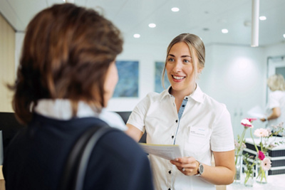 patient talking to woman at the front desk of the institute of radiology