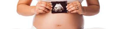 Frau hält Baby-Ultraschallbild vor Bauch