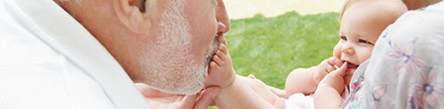 Happy grandparents playing with granddaughter in garden