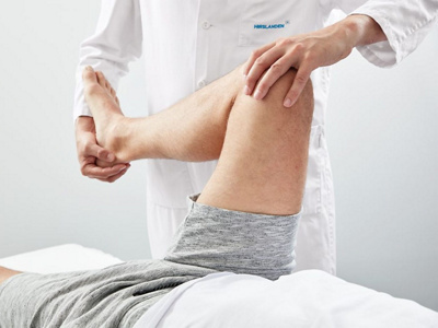 Arzt untersucht Knie eines Patienten