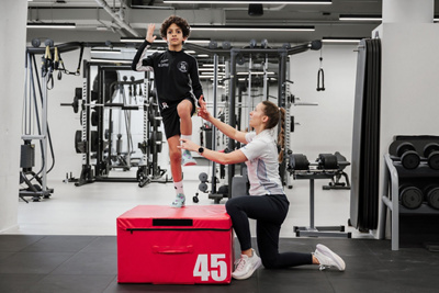 Physiotherapeutin unterstützt Kind bei Physiotherapie