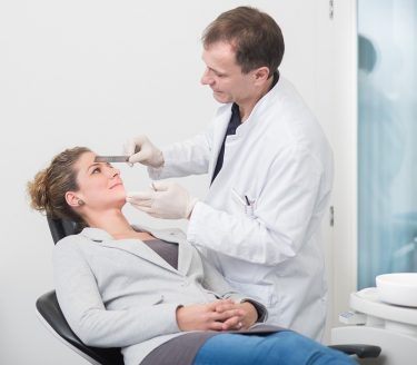 Le Dr Dennis Rohner avec une patiente à la prise de mesure Le traitement optimal du cancer de la cavité buccale nécessite une planification complète.